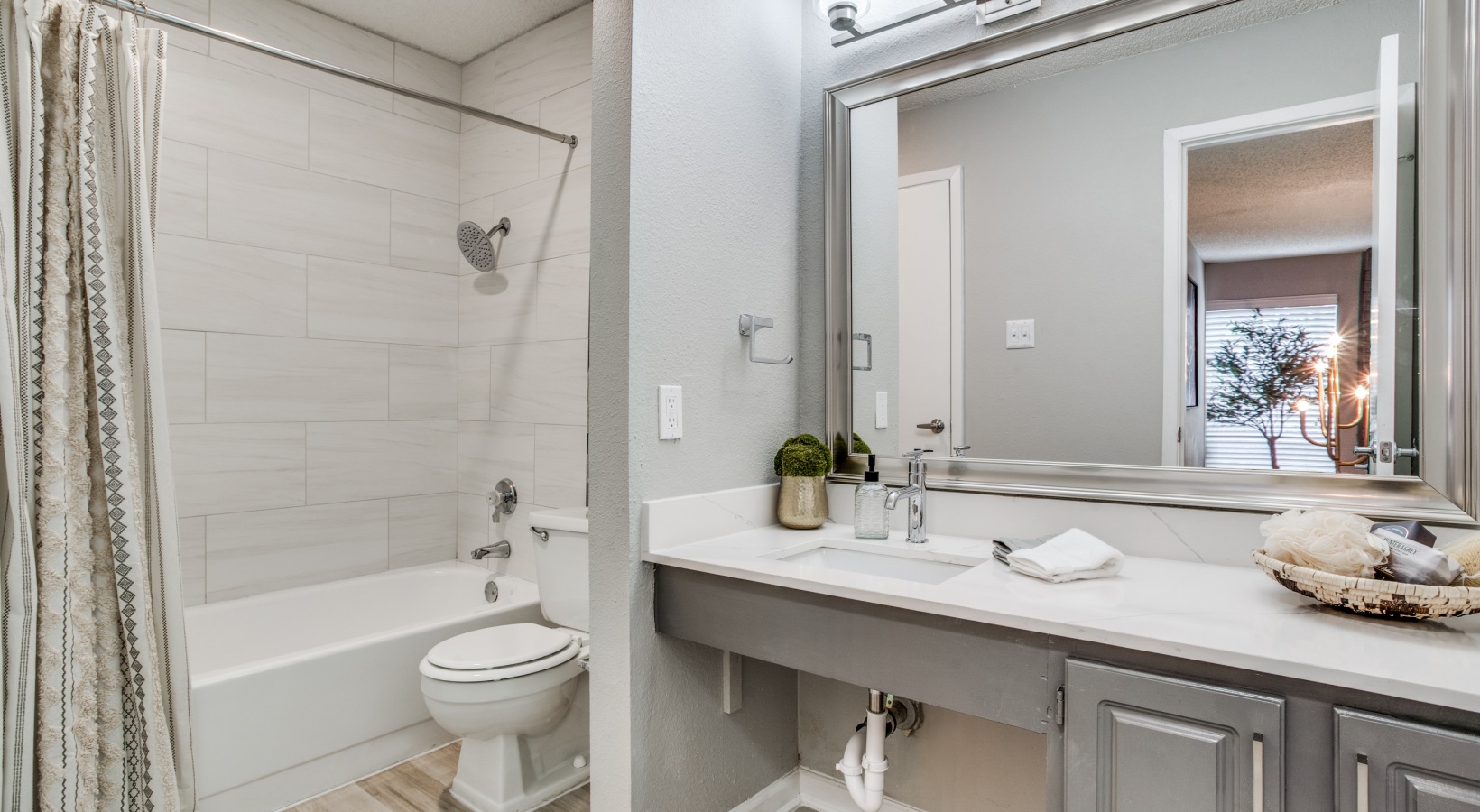 a bathroom with a white vanity and a tub at The Evaline