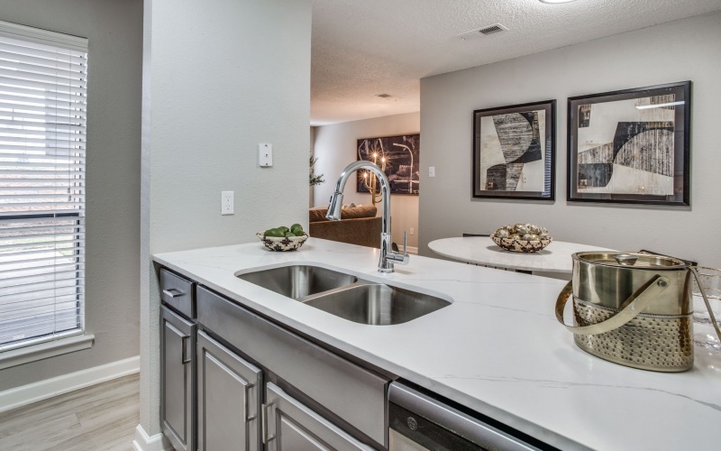 a kitchen with white cabinets and stainless steel appliances at The Evaline