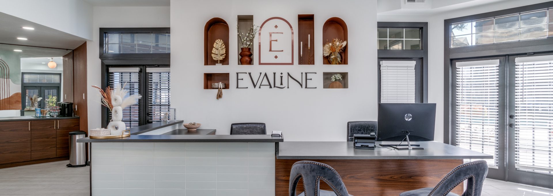 the front desk of a modern office with a large sign at The Evaline