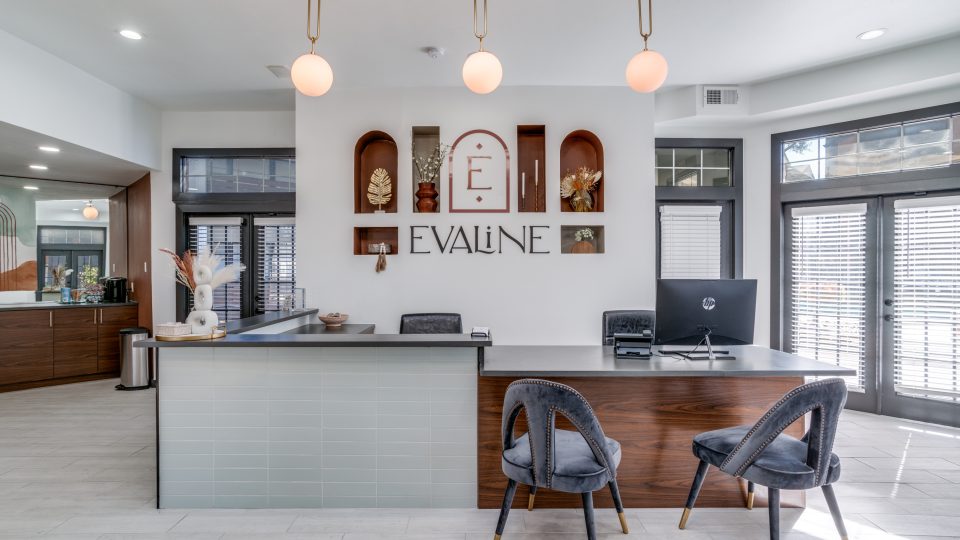 the front desk of a modern office with a large sign at The Evaline