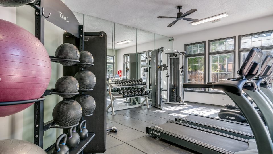 a gym room with exercise equipment and mirrors at The Evaline