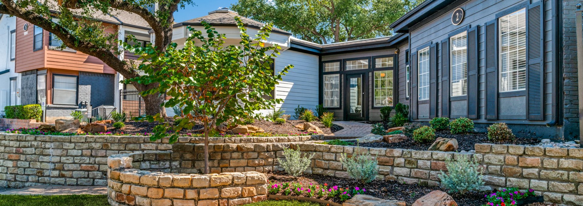 a home with landscaping and a stone wall at The Evaline
